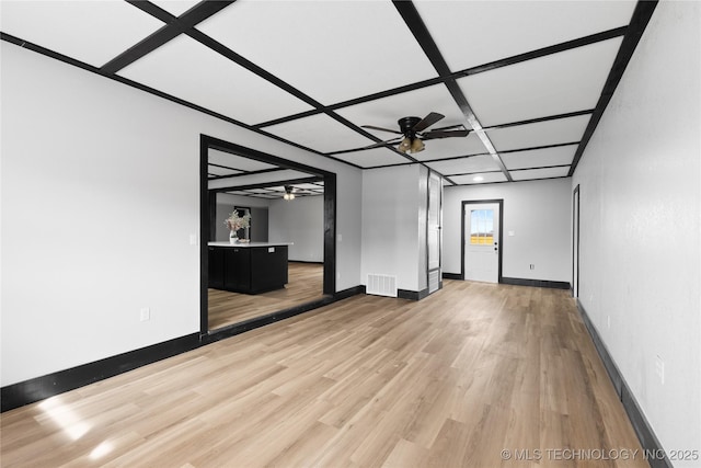 empty room featuring visible vents, baseboards, ceiling fan, light wood-style floors, and coffered ceiling