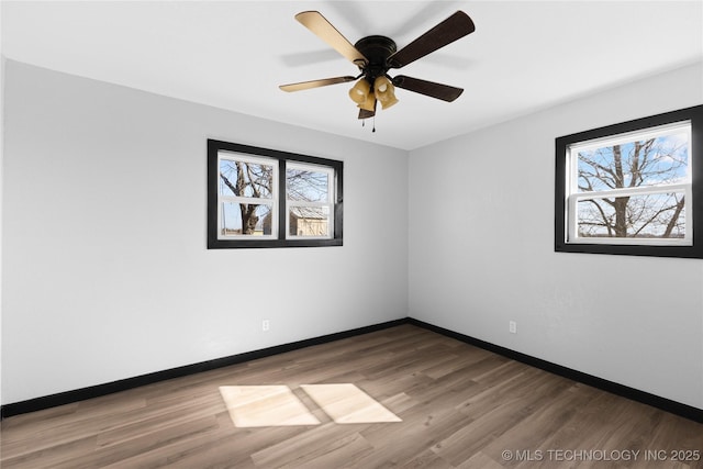 unfurnished room with wood finished floors, baseboards, and ceiling fan