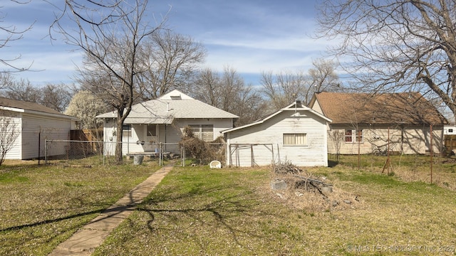 back of property with a yard and fence