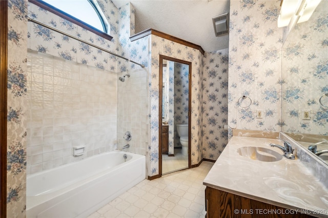 full bath with tub / shower combination, wallpapered walls, toilet, vanity, and a textured ceiling