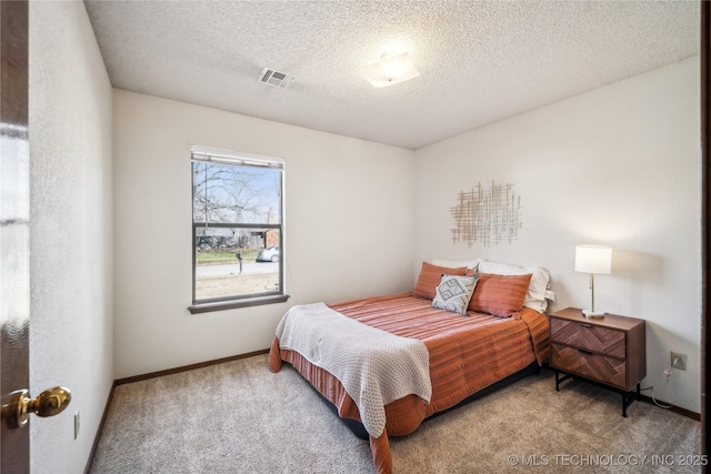 carpeted bedroom with visible vents, baseboards, and a textured ceiling