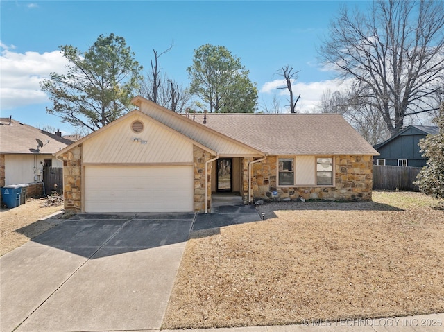 view of front of house with stone siding, fence, concrete driveway, an attached garage, and a shingled roof