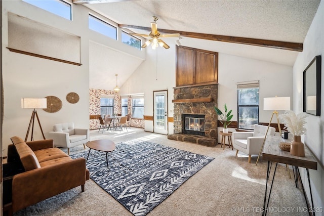 living room featuring a fireplace, ceiling fan, a textured ceiling, beamed ceiling, and carpet flooring