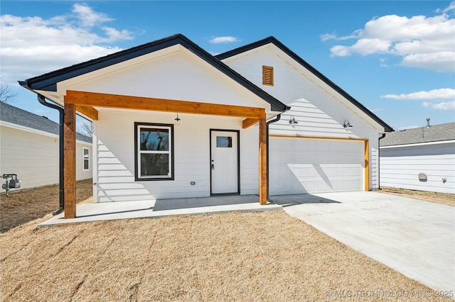 view of front of home with concrete driveway, an attached garage, and a porch