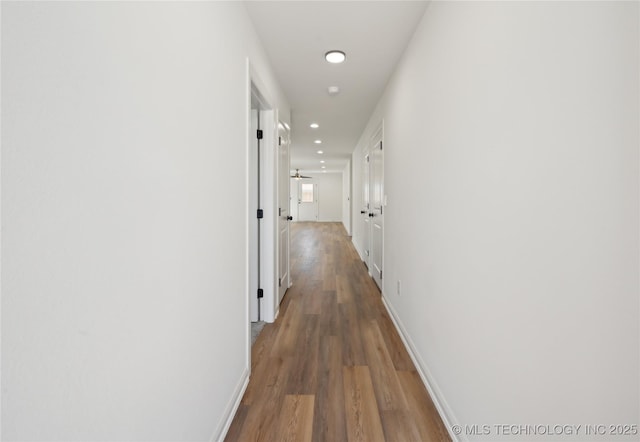 hallway featuring recessed lighting, baseboards, and wood finished floors