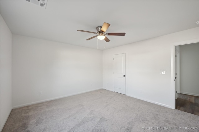 carpeted empty room with visible vents, baseboards, and a ceiling fan