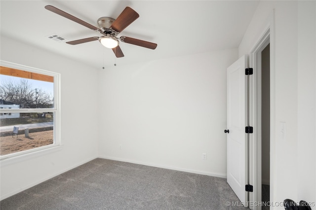 unfurnished room featuring visible vents, carpet floors, baseboards, and ceiling fan