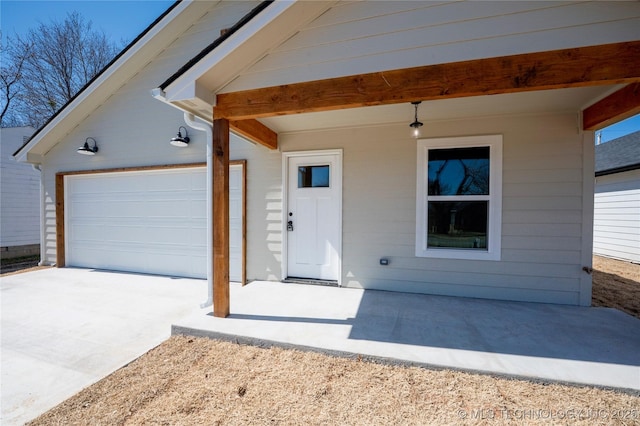 property entrance featuring concrete driveway and a garage