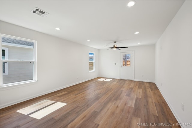 empty room featuring a ceiling fan, wood finished floors, visible vents, baseboards, and recessed lighting