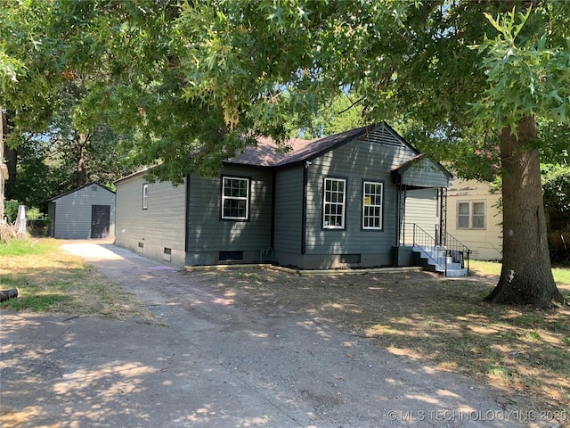 view of front of property with crawl space, a storage shed, and an outdoor structure