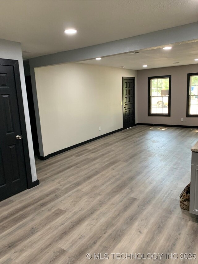 unfurnished room with recessed lighting, baseboards, and light wood finished floors