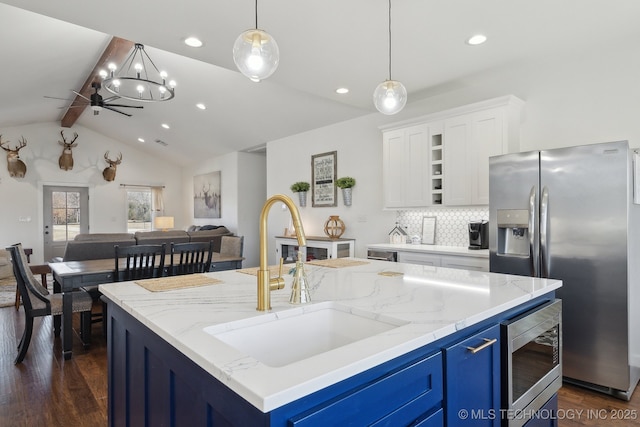 kitchen featuring dark wood-type flooring, blue cabinetry, a sink, open floor plan, and stainless steel appliances