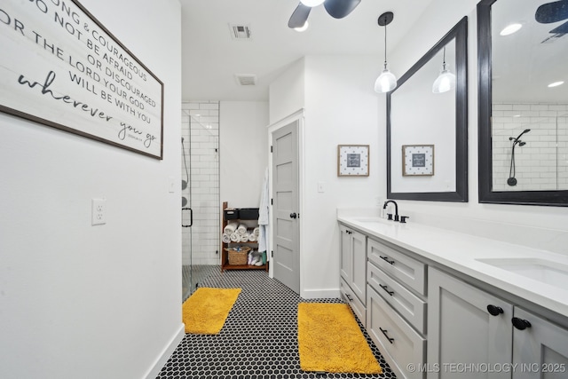 bathroom with double vanity, a stall shower, visible vents, and a sink