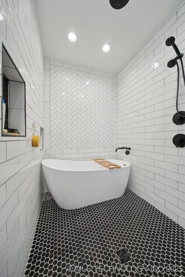 bathroom featuring tile patterned flooring, a soaking tub, tile walls, and tiled shower