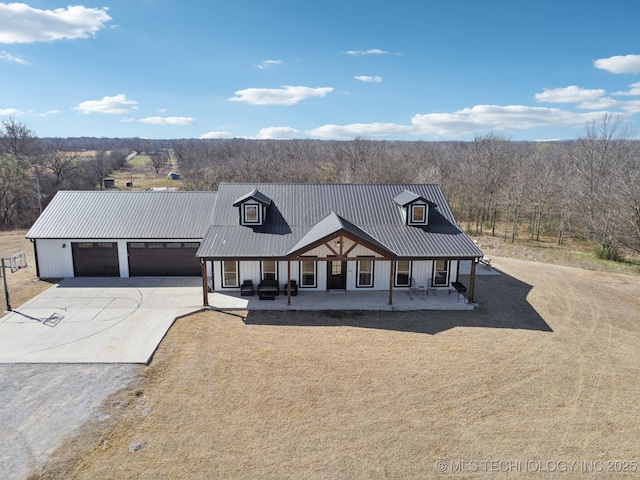 modern farmhouse style home featuring covered porch, driveway, and metal roof