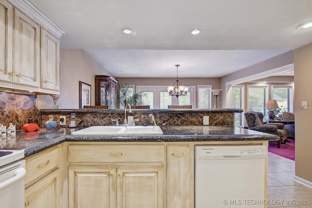 kitchen featuring white appliances, light tile patterned floors, an inviting chandelier, a sink, and backsplash