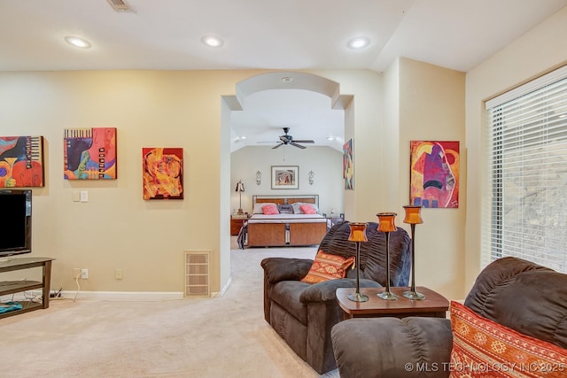 living room with visible vents, lofted ceiling, arched walkways, ceiling fan, and carpet flooring