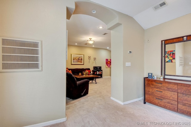 hallway featuring carpet flooring, baseboards, lofted ceiling, and visible vents