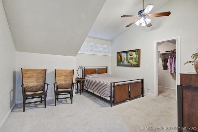 carpeted bedroom featuring baseboards, a ceiling fan, a spacious closet, and vaulted ceiling