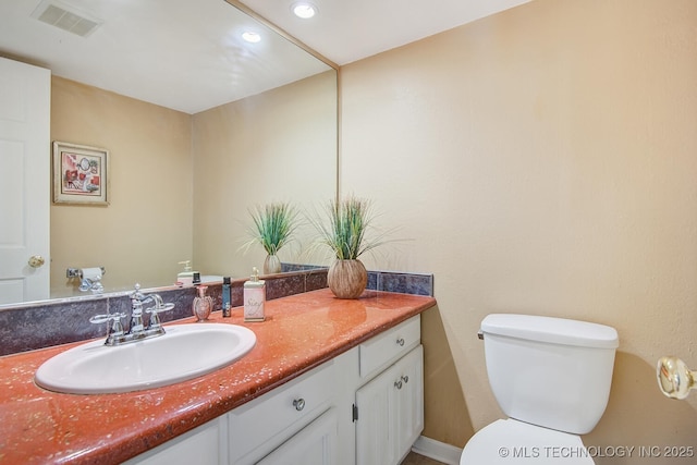 bathroom featuring vanity, toilet, recessed lighting, and visible vents