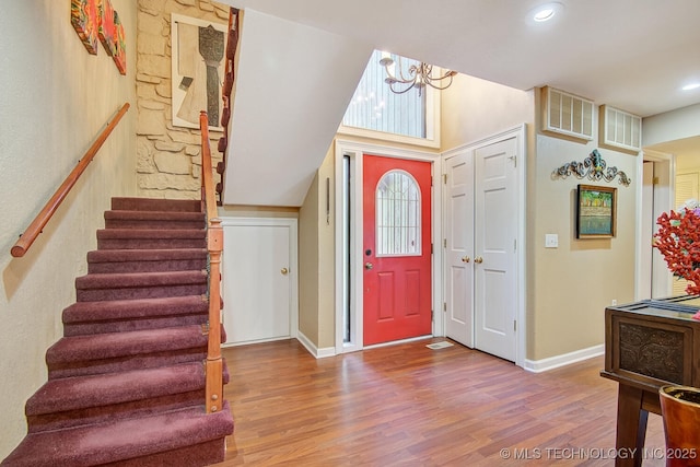 entryway with visible vents, stairs, and wood finished floors