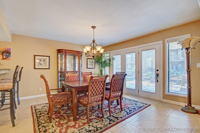 dining area featuring light tile patterned floors, a notable chandelier, a healthy amount of sunlight, and french doors