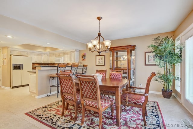 dining space with plenty of natural light, light tile patterned floors, and a chandelier