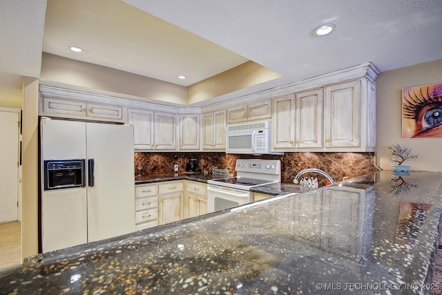 kitchen with backsplash, white appliances, and dark stone countertops