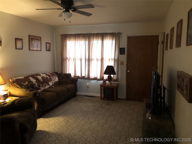 living area with visible vents, baseboards, and ceiling fan