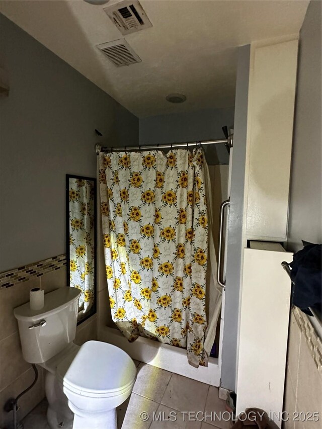 3730 Governor Harris St, Ada, OK 74820 - full bath featuring tile patterned flooring, visible vents, curtained shower, toilet, and tile walls