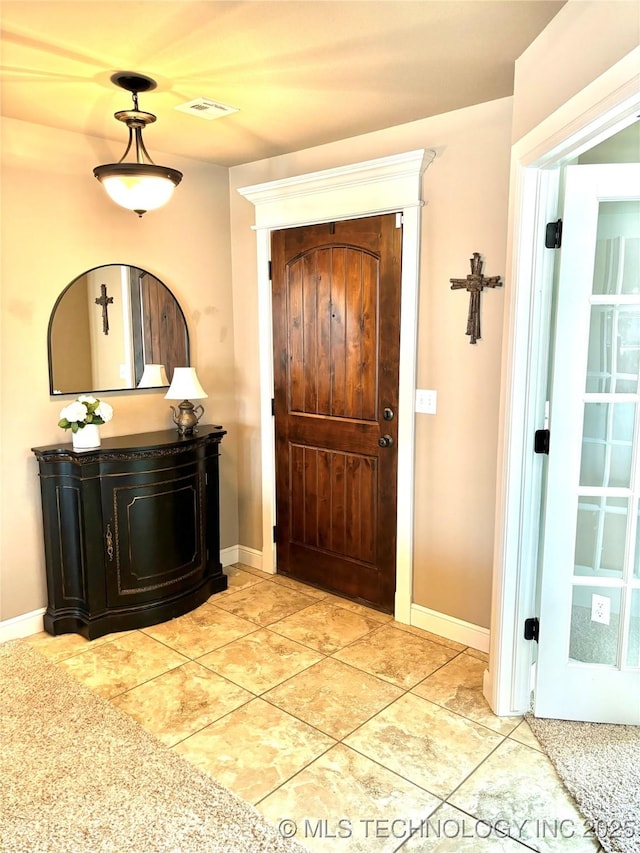 entrance foyer with light tile patterned floors, visible vents, and baseboards