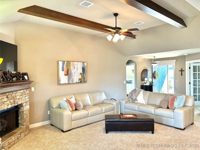 carpeted living area featuring lofted ceiling with beams, visible vents, arched walkways, and a fireplace