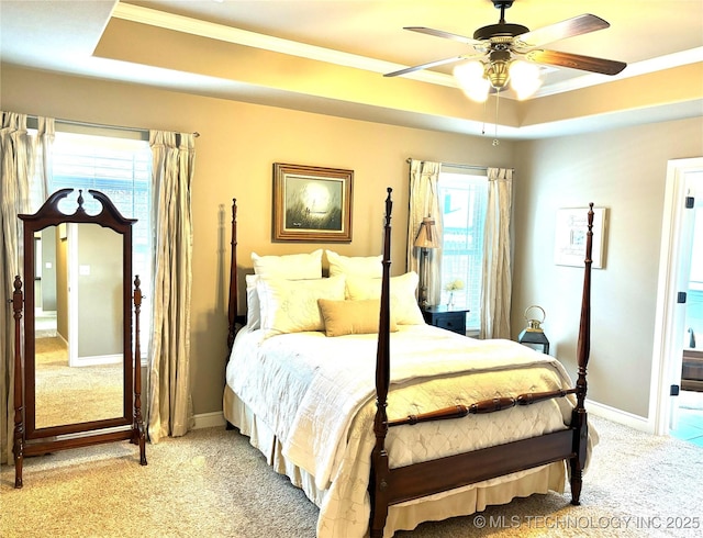 bedroom with baseboards, a raised ceiling, light colored carpet, and ornamental molding