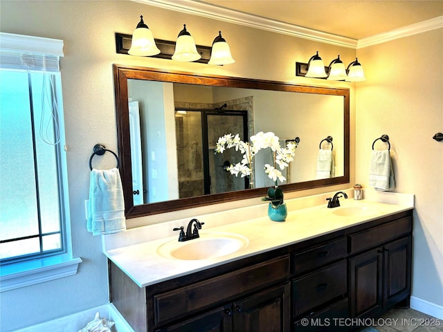 bathroom with a tile shower, double vanity, crown molding, and a sink