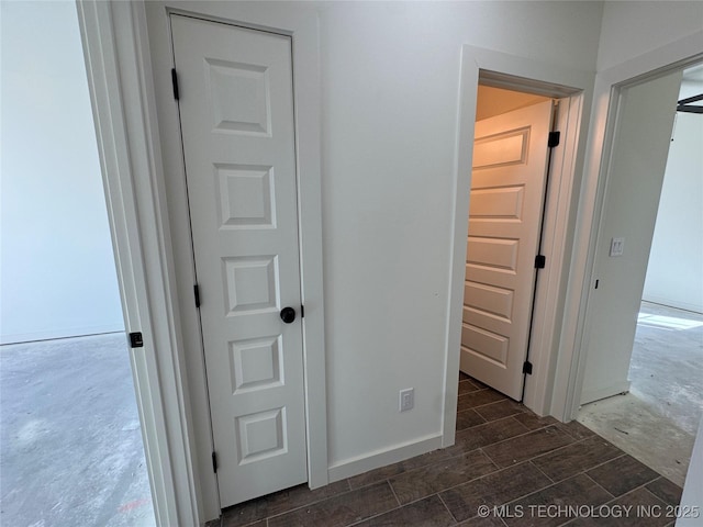 corridor featuring baseboards and wood tiled floor