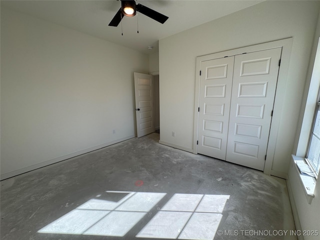 unfurnished bedroom featuring a closet, unfinished concrete floors, and a ceiling fan