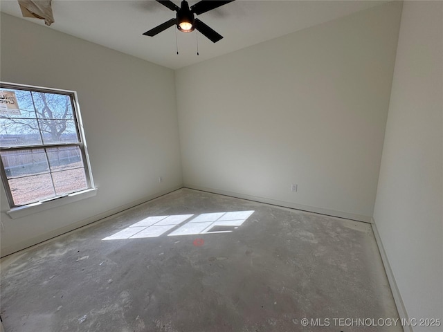 spare room featuring unfinished concrete flooring and ceiling fan