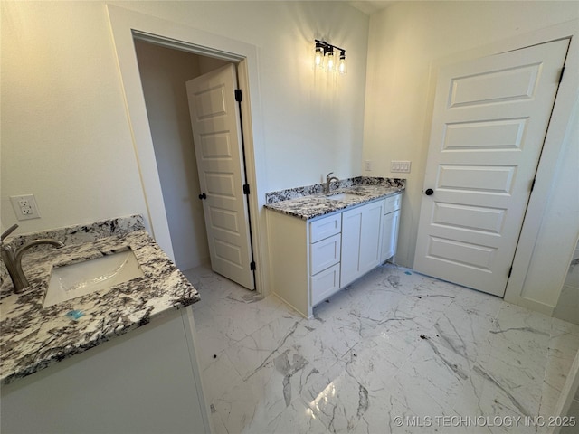 bathroom featuring two vanities, marble finish floor, and a sink