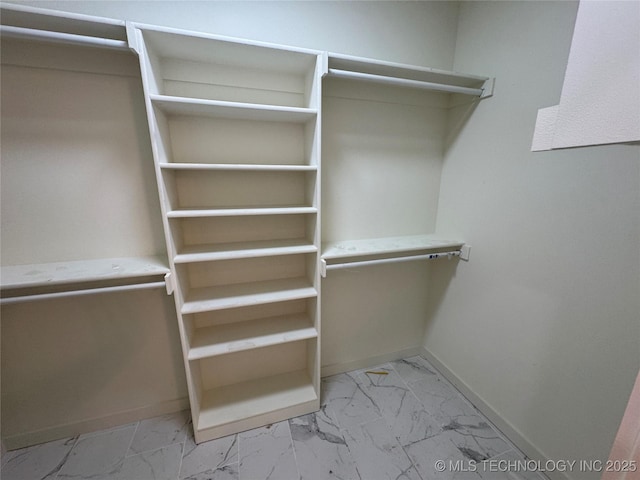 walk in closet with marble finish floor