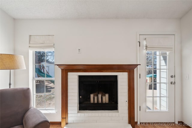 living area with a fireplace and a textured ceiling