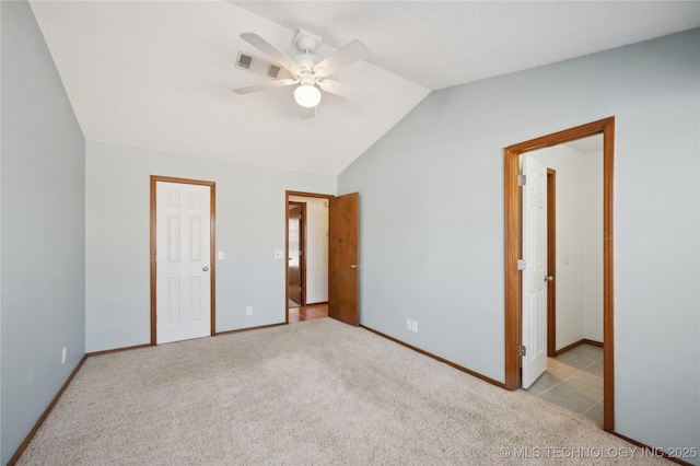 unfurnished bedroom with visible vents, a ceiling fan, carpet flooring, baseboards, and vaulted ceiling