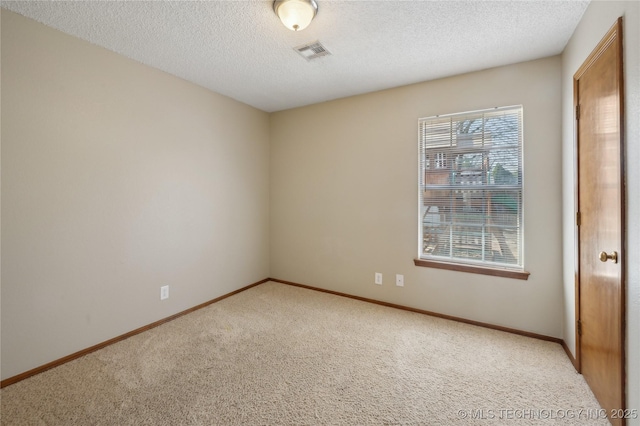 carpeted spare room featuring visible vents, baseboards, and a textured ceiling