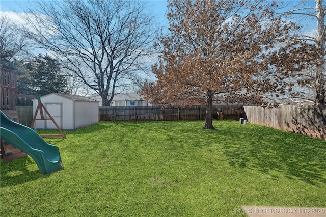 view of yard featuring an outbuilding, a storage shed, a playground, and a fenced backyard