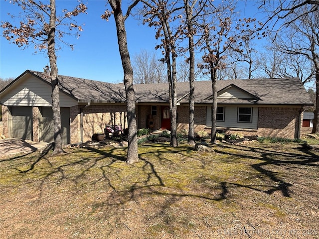 view of front of house featuring a front yard, brick siding, and a garage