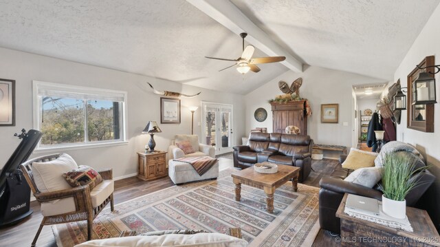 living area with baseboards, lofted ceiling with beams, ceiling fan, and wood finished floors