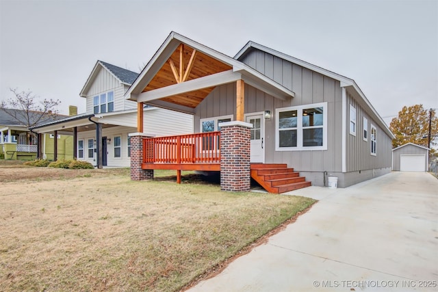 view of front of property with a front lawn, a detached garage, board and batten siding, an outdoor structure, and concrete driveway