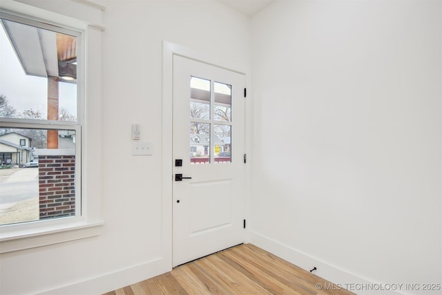 entryway with light wood-type flooring and baseboards