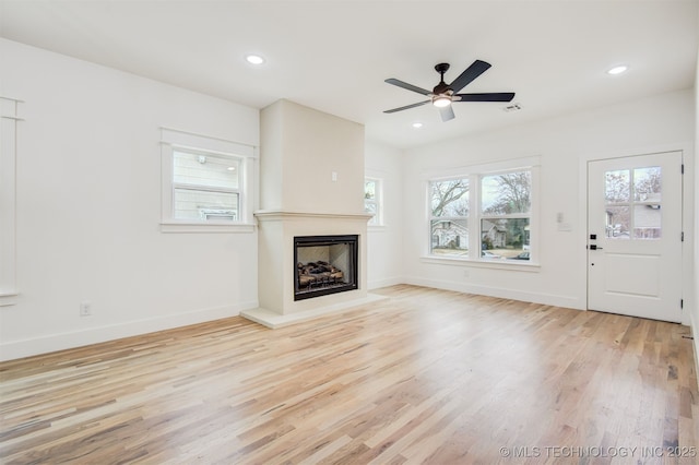 unfurnished living room featuring recessed lighting, baseboards, and wood finished floors