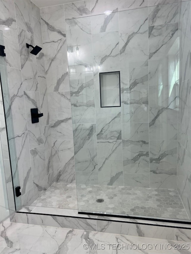 bathroom with a marble finish shower