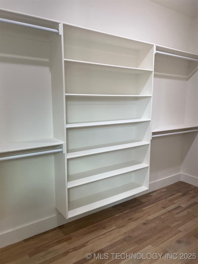 walk in closet with wood finished floors